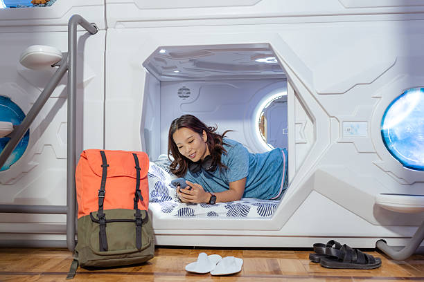 istock Chinese woman relaxing in a capsule hostel while using her smartphone 2222299712