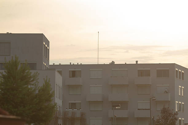 istock A large building with many windows is surrounded by trees and clouds 2222302066
