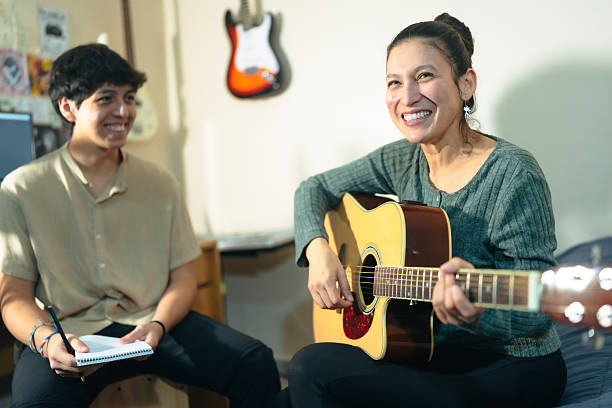 istock Music teacher playing acoustic guitar and teaching student 2222302708