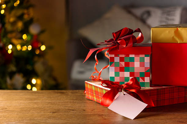 istock Christmas Gift Boxes with Red Ribbons and Tag on Wooden Table 2222302819