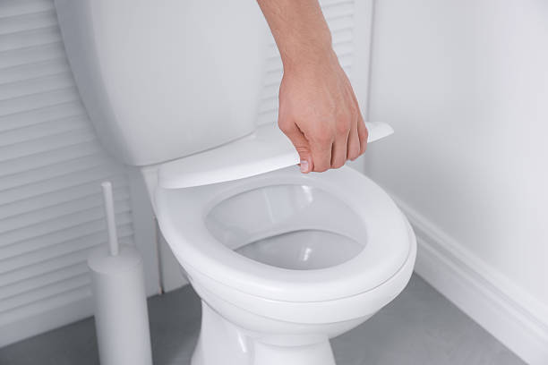 istock Man closing toilet seat in bathroom, closeup 2222306093