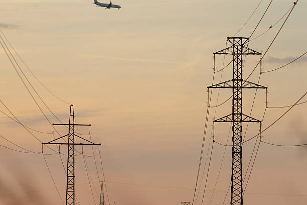 istock A commercial plane is flying high over power lines during sunset 2222306238