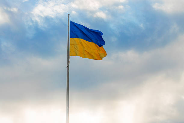 istock Ukrainian waving flag independence day wallpaper concept poster with light glare empty copy space and blurred sky background 2222309552