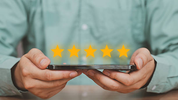 istock Customer Feedback and 5-Star Rating, smartphone with five glowing stars displayed above, representing excellent customer feedback, review system, or service satisfaction in a digital context. 2222314748