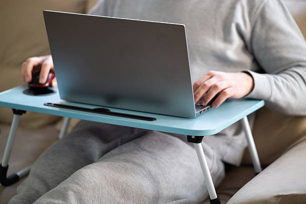 istock Man working on laptop computer on portable table at home 2222314934