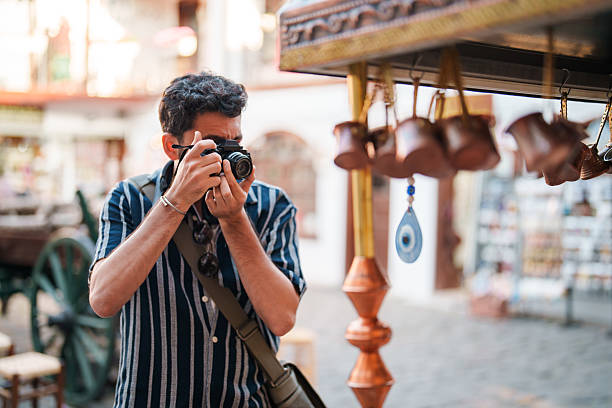 A man captures the essence of Turkish coffee craftsmanship as he photographs a traditional coffee making station. The scene reflects the artistry and cultural richness of Turkish coffee preparation.