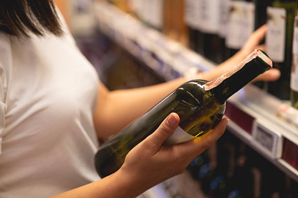 istock Young woman choosing a wine from the beverage aisle 2222324320