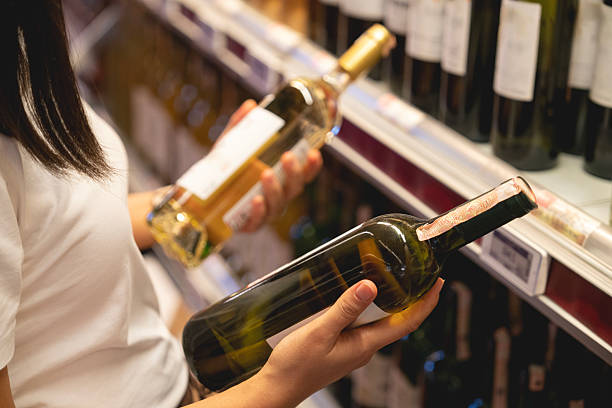 istock Young woman choosing a wine from the beverage aisle 2222324335