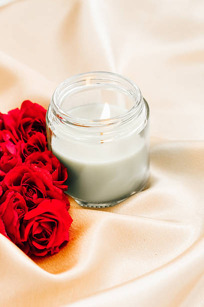 istock Elegant candle and red roses on silky fabric create a romantic atmosphere for special occasions 2222326348