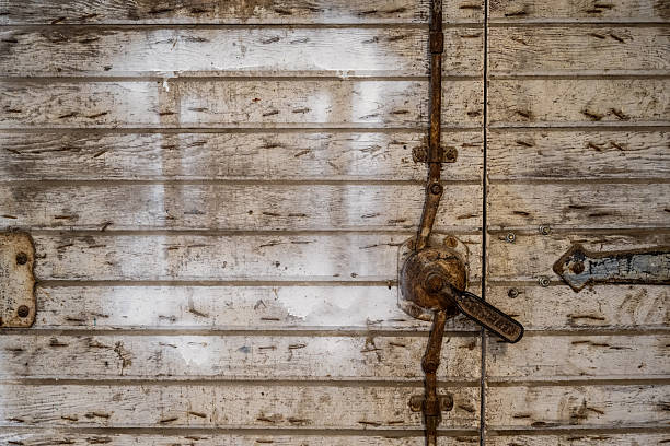 Close-up of padlock on rustic old wood door