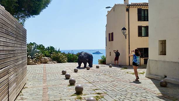 19 April 2025, Palma de Mallorca, Spain. A sunlit coastal monument rises above the rocks in Palma de Mallorca, offering a tranquil meeting point between land, sea, and sky.
