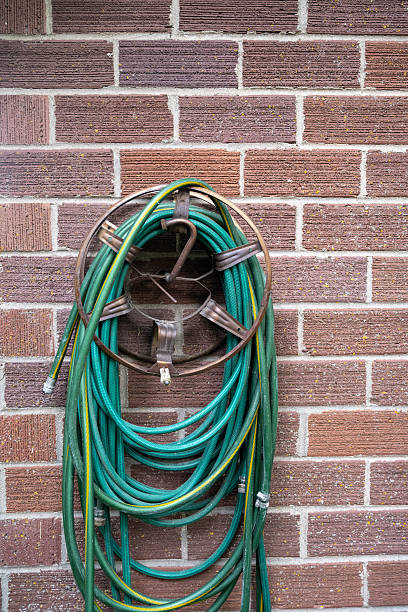 istock Garden hose hanging on a brick wall 2222326920