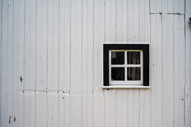 Stockholm, Sweden A red wooden cabin in the Sollentuna suburb and abroken window.