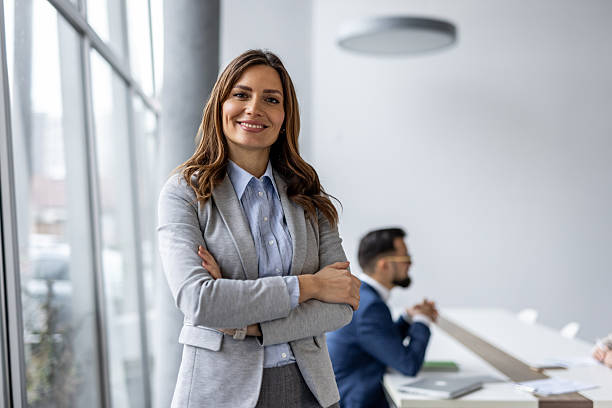 istock Confident businesswoman smiling with folded arms in modern office 2222328320