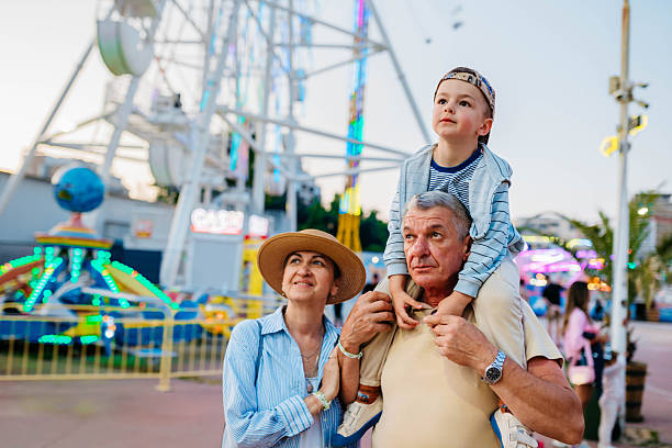 Grandparents having fun in an amusement park with their grandson