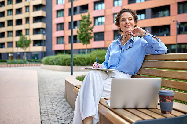 istock Businesswoman taking notes and thinking about new ideas while working outdoor 2222331822