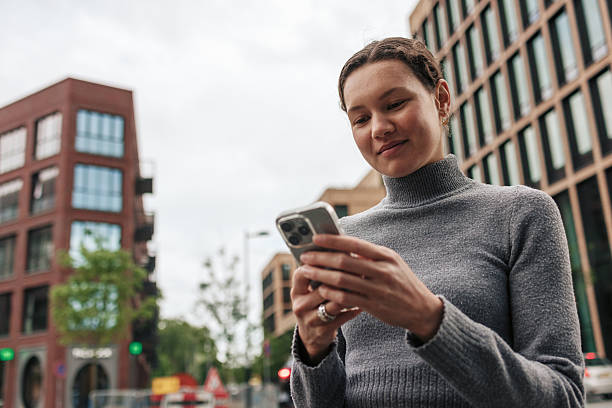 istock Young woman using smartphone in urban city setting 2222338284