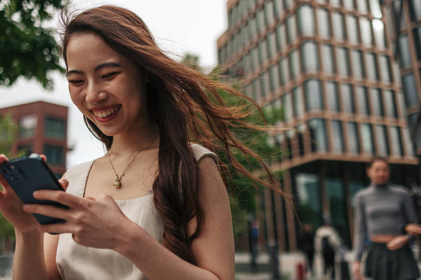 istock Young Asian Woman Using Smartphone in Urban Setting 2222338364