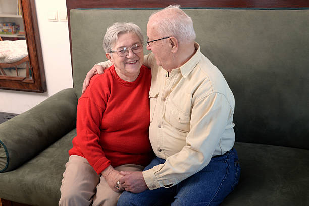 istock Senior couple sitting on the couch at home and talking 2222342499