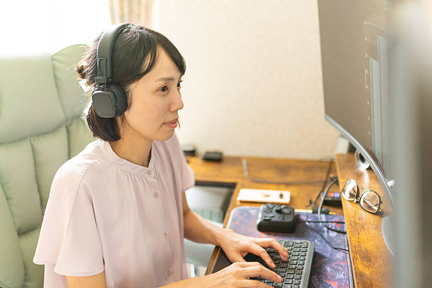 istock A woman wearing headphones, working at home on a computer 2222343918