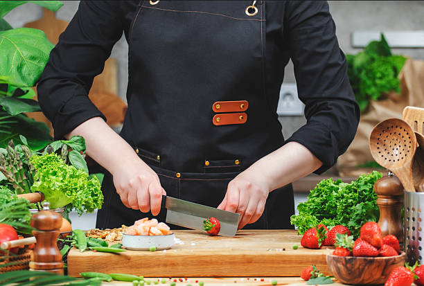 istock In bright kitchen chef skillfully slices fresh strawberries surrounded by vibrant vegetables and herbs, creating a healthy dish. 2222349386
