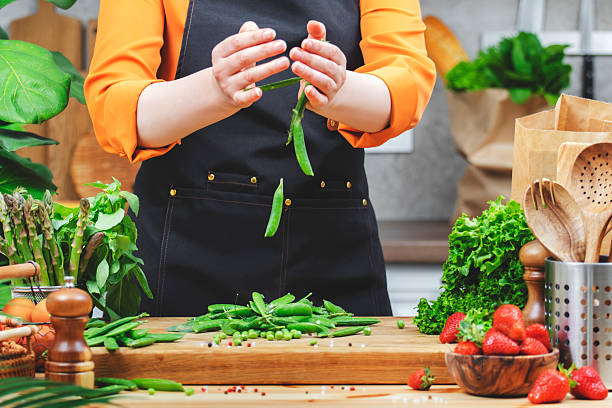 istock Chef prepares fresh green peas and vegetables and strawberries in a vibrant kitchen setting focused on healthy vegan cooking 2222349398