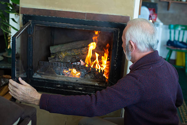 A bio-ethanol fireplace burns with orange flames in a dark room