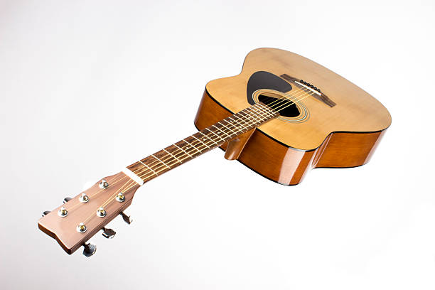 dreadnought six-string acoustic guitar made of light wood on a white background. an isolated object. close-up. with a place for the text. view from below