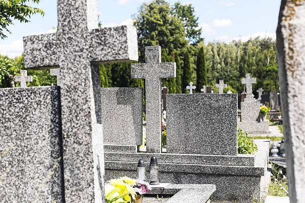 istock Granite gravestones in cemetery. Traditional tombs in peaceful graveyard. Religious monument under blue sky. 2222361743