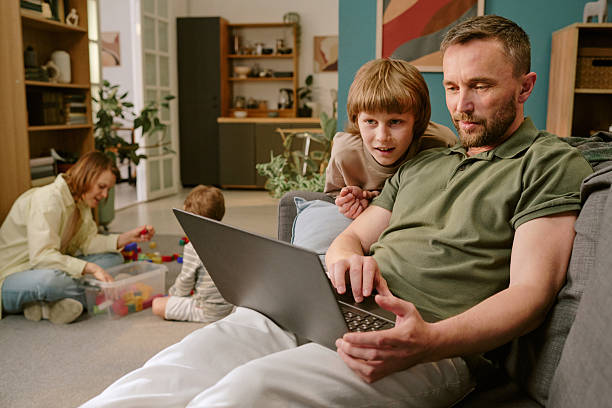 istock Middle Aged Man Working Remotely While Family Spending Time Nearby 2222365670