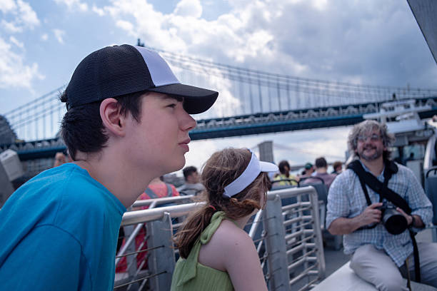 istock Cruise passengers viewing bridge. Son with autism and his sister enjoy harbor tour while father takes photos. 2222366904