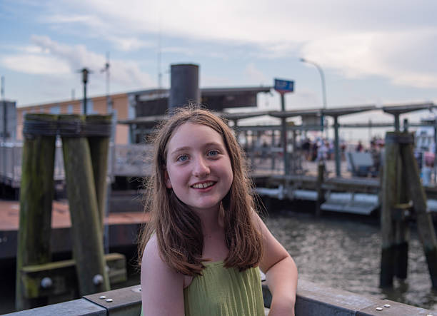 istock Smiling preteen at ferry dock. Waterfront terminal with passengers in background. 2222366954