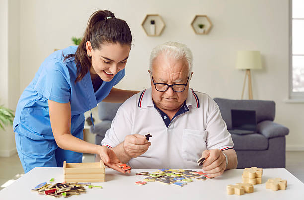 istock Nurse in retirement home is helping demented senior patient with puzzle activity 2222367309