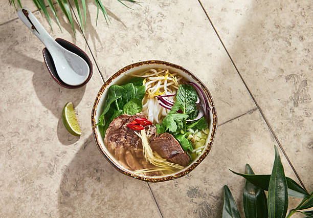 istock Pho bo soup with fresh herbs, bright natural lighting, overhead bowl composition 2222371708
