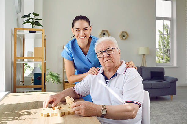 istock Elderly man with caregiver solving puzzles as memory training against Alzheimer's and dementia. 2222372779