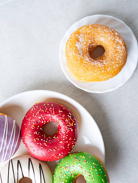 istock Donuts with colorful icing glazed designs on a white background. Copy free space 2222373795