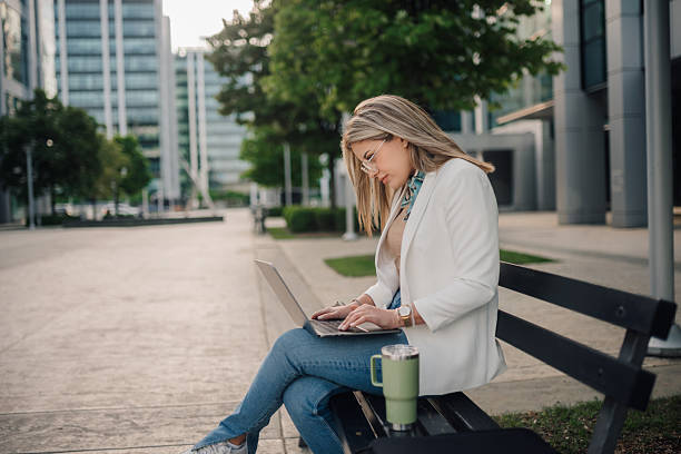 istock Businesswoman working on laptop outdoors in urban setting 2222376723
