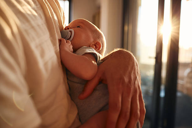 Young father is holding his newborn baby stock photo