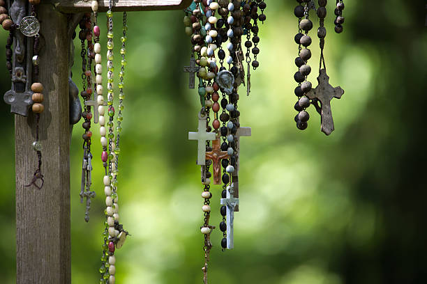 istock Various rosaries with crosses and beads hang against a soft, green backdrop. 2222380837