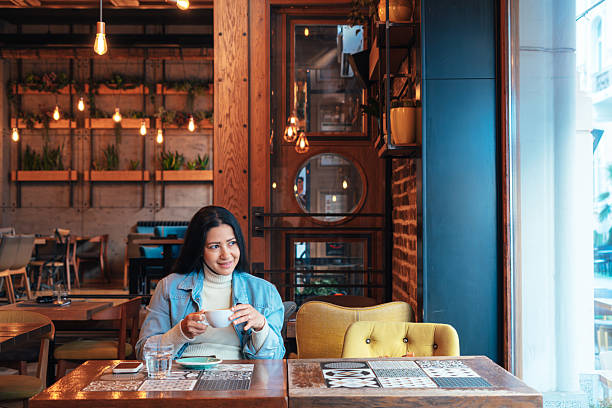 istock Young Woman Enjoying a Coffee Break in a Cozy Cafe 2222381499