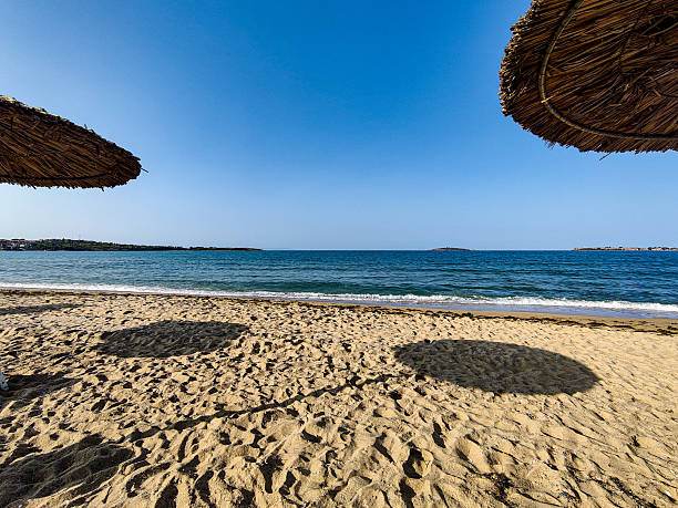 Beach, sea, empty sky and island in the distance