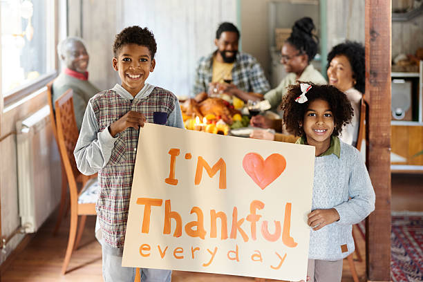 istock Happy black siblings feeling grateful during Thanksgiving with their family. 2222384203