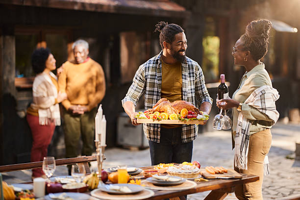 istock Happy black couple talking while setting the picnic table for Thanksgiving. 2222384743