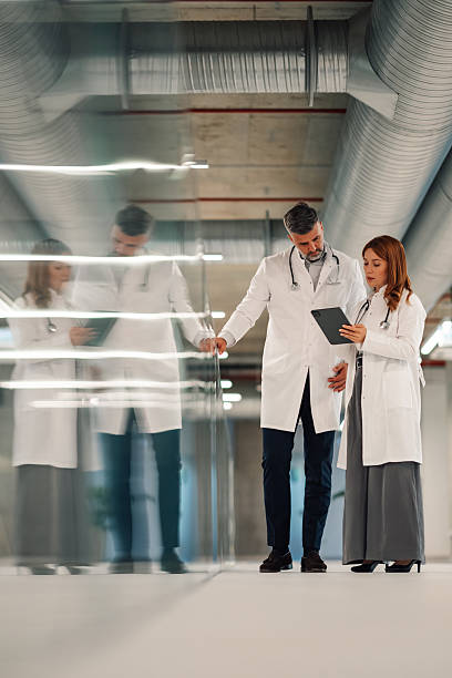 istock Doctors consulting on digital tablet in hospital corridor 2222386397