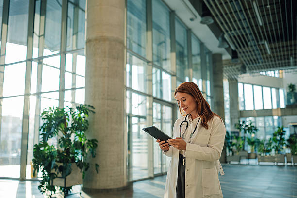 istock Female doctor using digital tablet in modern hospital lobby 2222386470
