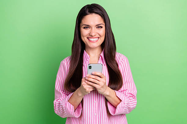 istock Portrait of attractive cheerful girl holding in hands using device browsing post smm app isolated over green pastel color background 2222387925
