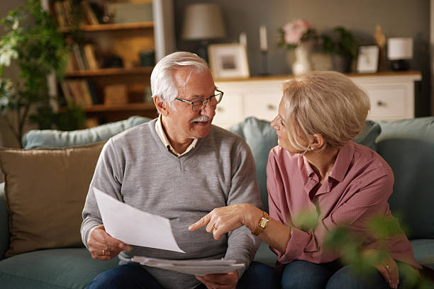 istock Senior couple reading documents and discussing life insurance at home 2222390128