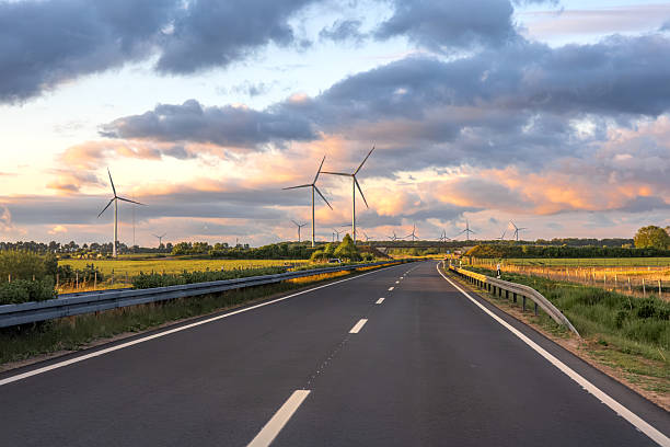 istock Wind turbines above road. Rural landscape. Sunset sky 2222391082