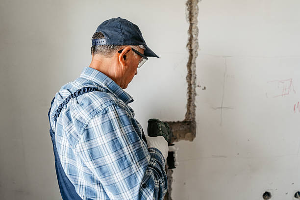 istock Senior Male Worker Drilling The Wall In An Empty Apartment Under Renovation 2222391472