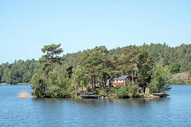 Serene footpath leading to a charming red fishing hut in the idyllic gothenburg archipelago, a picturesque summer scene in sweden